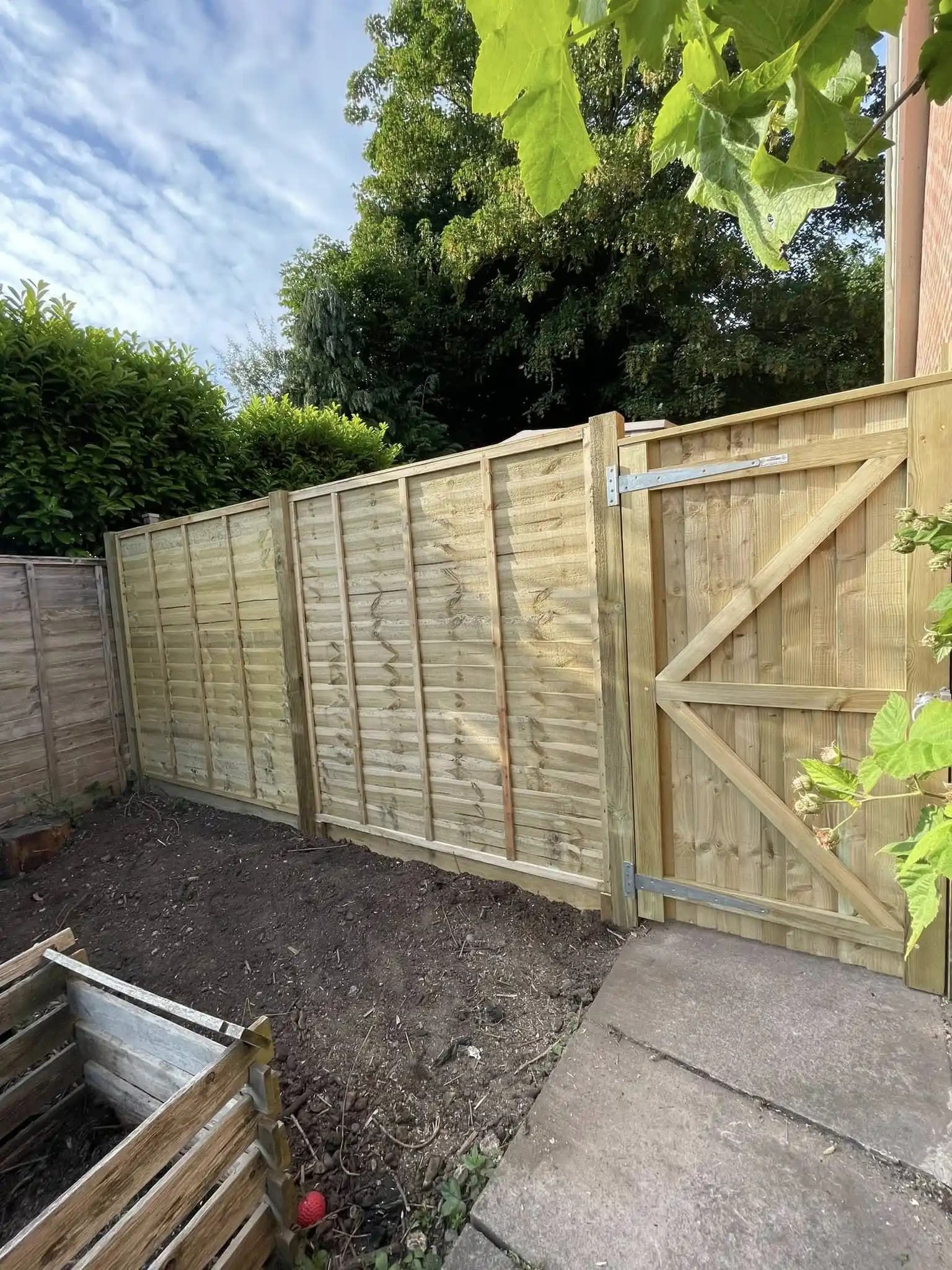Closeboard timber fence with matching side gate installed for a secure garden boundary.
