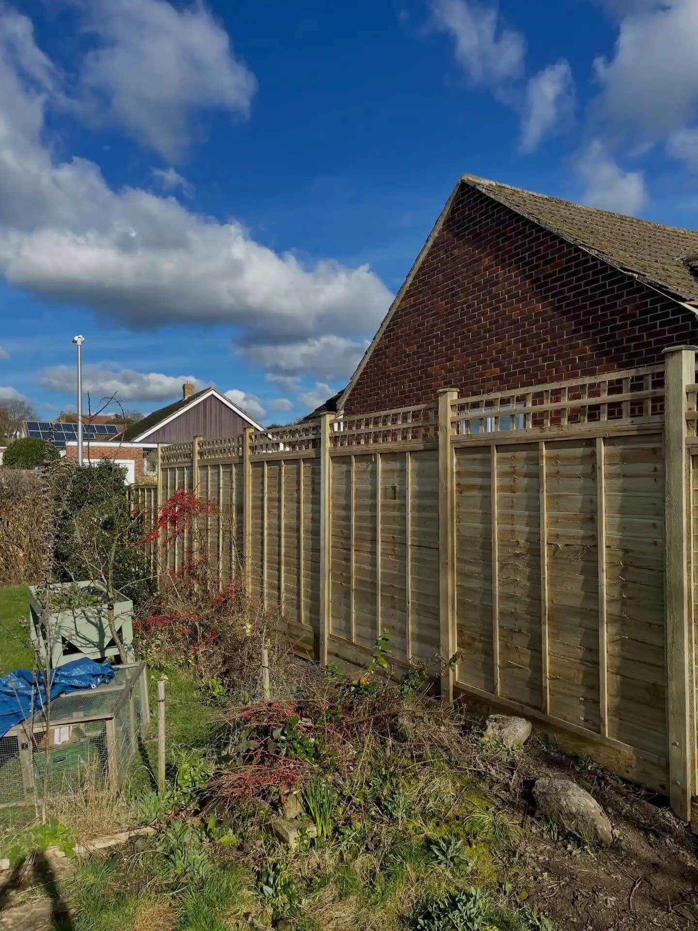 Existing tired garden fence and patio area before a new fencing and landscaping upgrade.