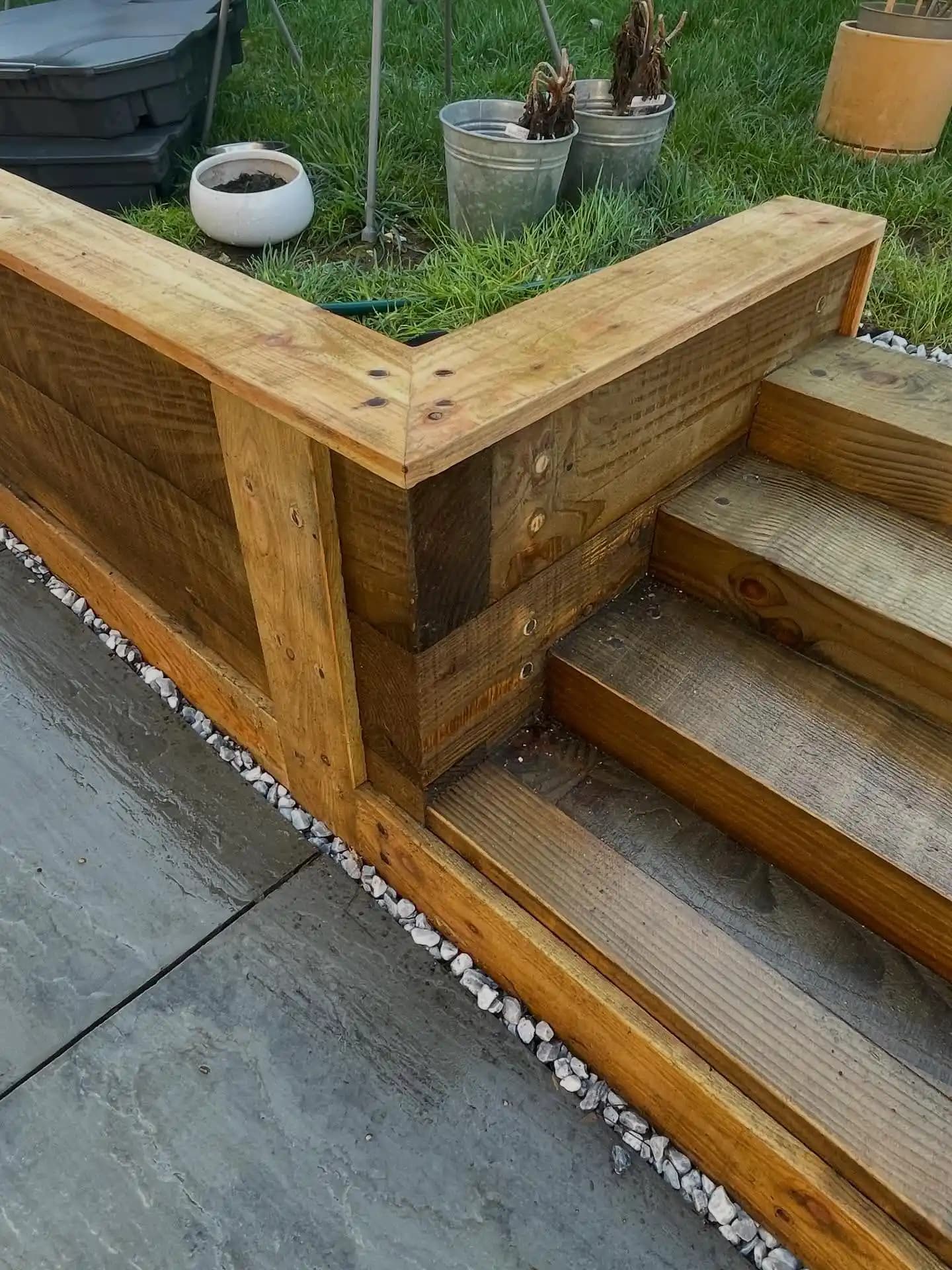 Traditional timber fence panels with trellis tops installed along a garden boundary under a bright blue sky.